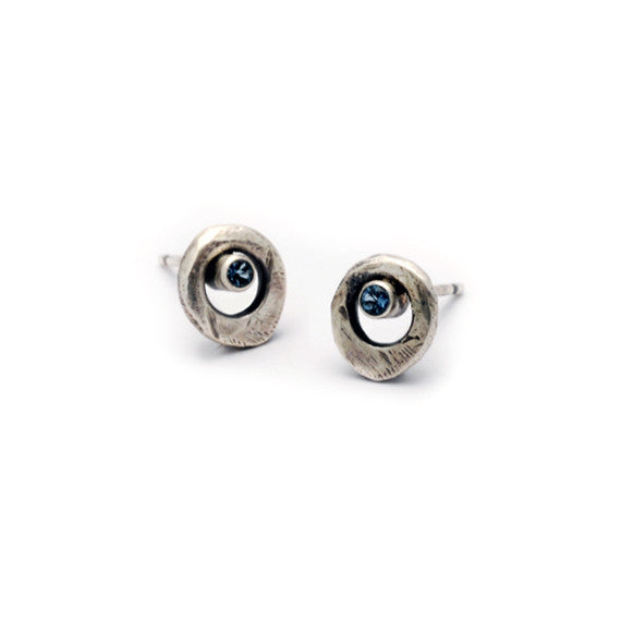 Forged silver circle studs set with brilliant cut blue topaz by Annika Rutlin